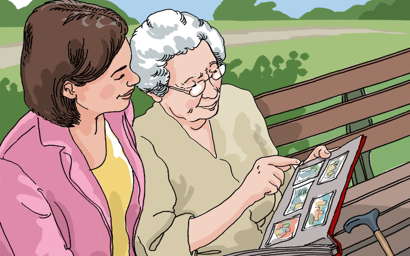Older woman with a younger woman looking at a photo album